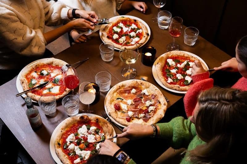 Four people eating pizza